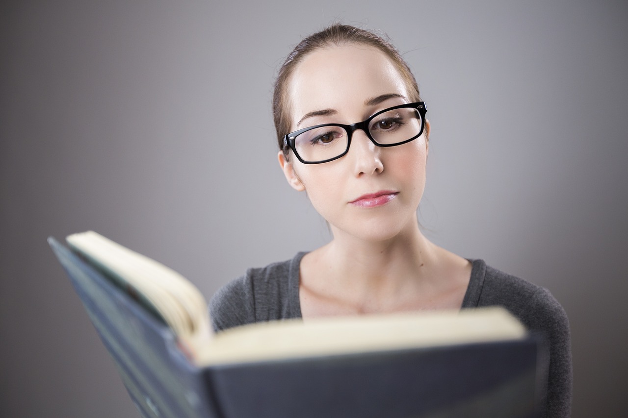 眼鏡をかけた女性が本を読んでいる